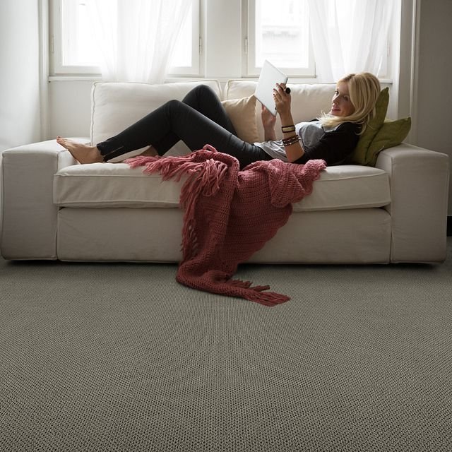 Woman laying on sofa with salmon colored blanket - Carpet Studio & Design Inc. in Los Angeles, CA