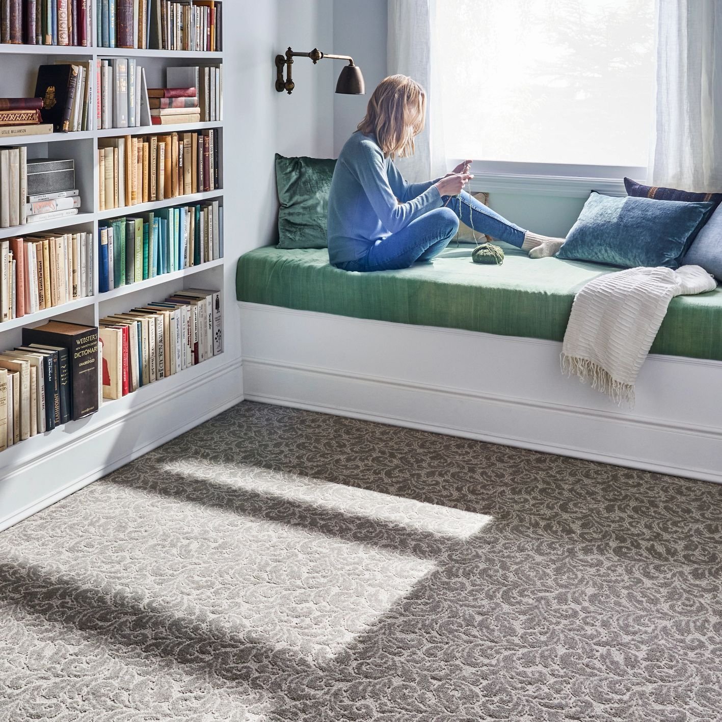 Reading in bed having a beautiful view from window in a bedroom with white furniture and brown carpet from Carpet Studio & Design Inc. in Los Angeles, CA