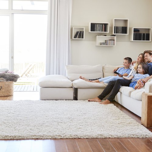 Family watch tv from a big white couch from Carpet Studio & Design Inc. in Los Angeles, CA