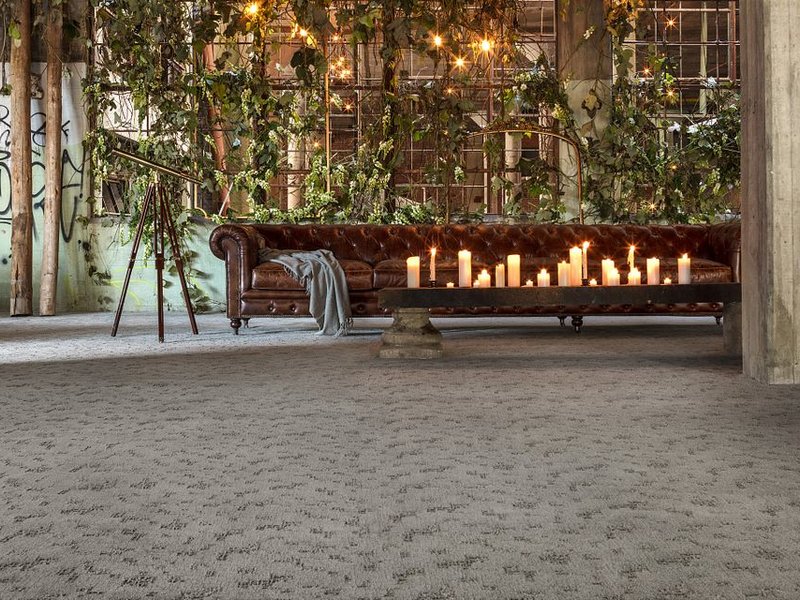 brown leather couch and a table with candled in a big open space room with beige carpet from Carpet Studio & Design Inc. in Los Angeles, CA