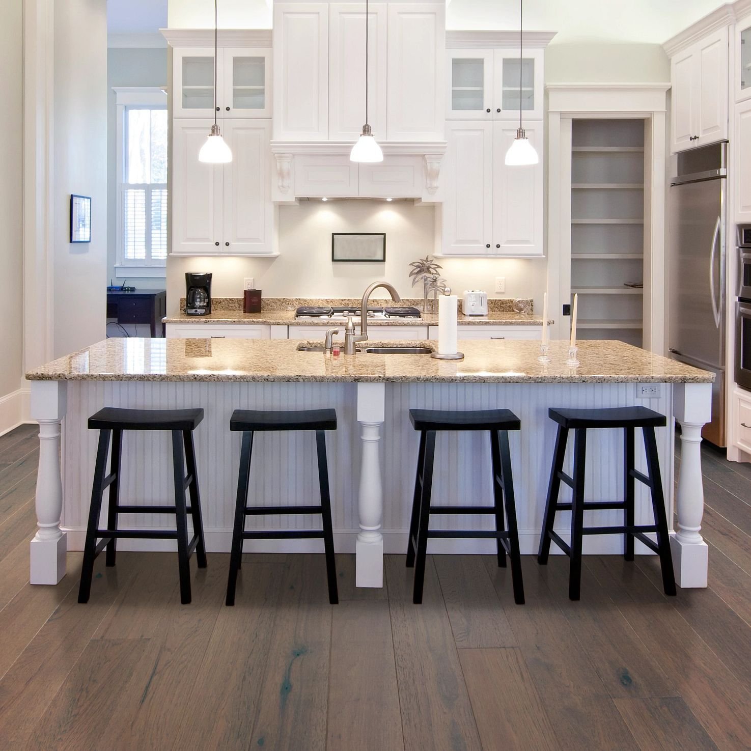 White island table with black chair in kitchen room having a brown hardwood floor from Carpet Studio & Design Inc. in Los Angeles, CA